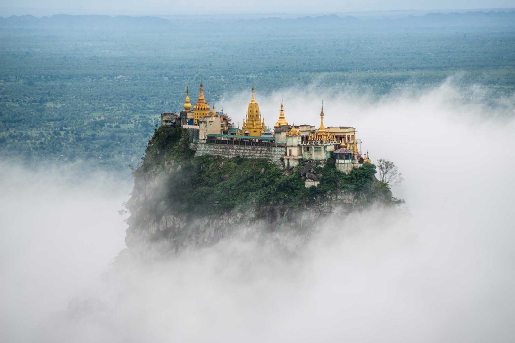 Destinations Worth Dreaming Image: A beautiful structure sits atop a mountain shrouded in mist.