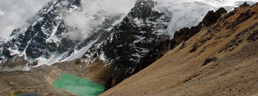 Best Hikes In Peru Image: The turquoise pool of the hot spring sits is secluded in the mountain's landscape.