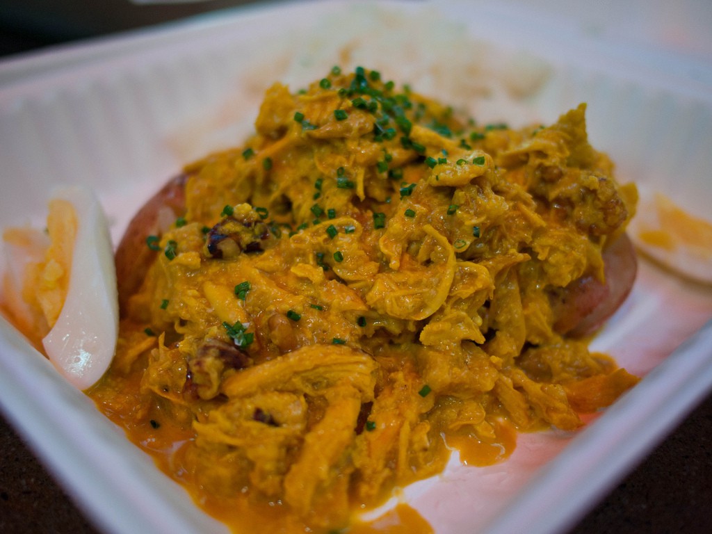 Visit Peru Image: A hard-boiled egg is sliced in half beside the creamy chicken dish this section of our Peru food tour list describes.