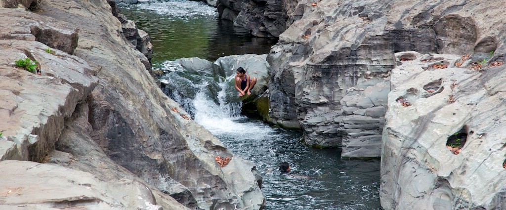 Swimming Holes Image: People perch amongst the boulders and enjoy the cool waters of this Panamanian swimming hole.