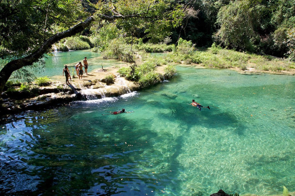 Swimming Holes Image: Several people are pictured taking in the view of the swimming holes, and enjoying a swim in their waters.