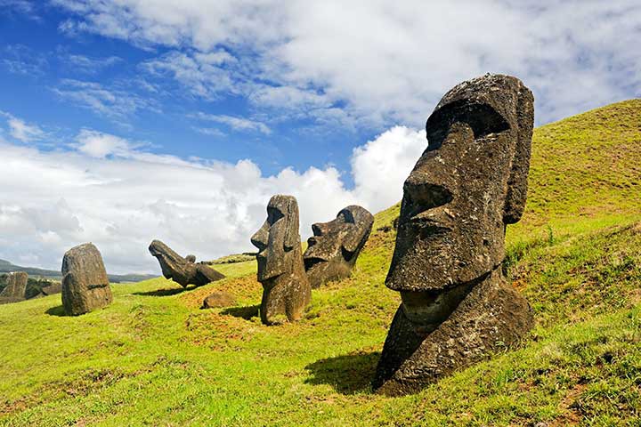 Destinations Worth Dreaming Image: Five moai are visible—three are upright; one is tilted forward, and another is tilted back.