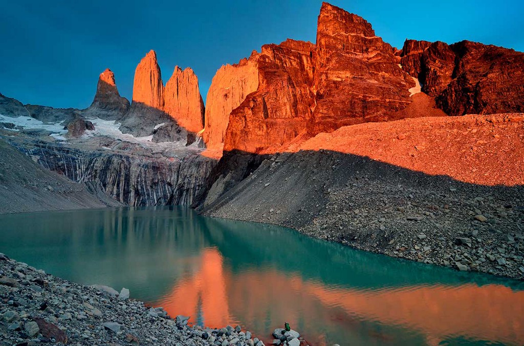 Destinations Worth Dreaming Image: A mountain scene displays the colours of nature in rocks, dusty peaks, and flowing water.