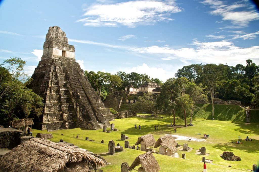 Central and South American Ruins Image: A dramatic pyramid overwhelms a small village in a valley.