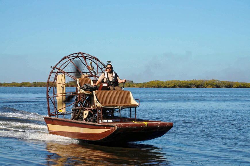 Belize River Tour Image: An airboat rushes over the water.