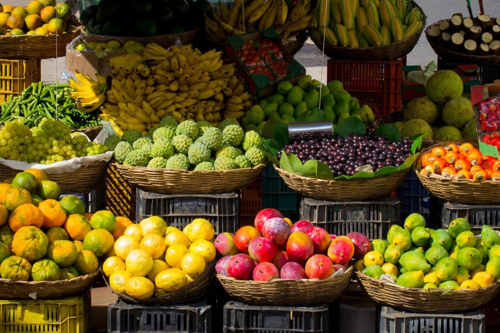 Costa Rican Foods Image: A market stand full of colourful baskets of tropical fruits.