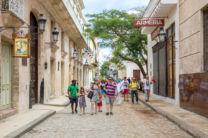 Family Vacations Image: A young family enjoys walking down a foreign street, sharing the sights with the children.