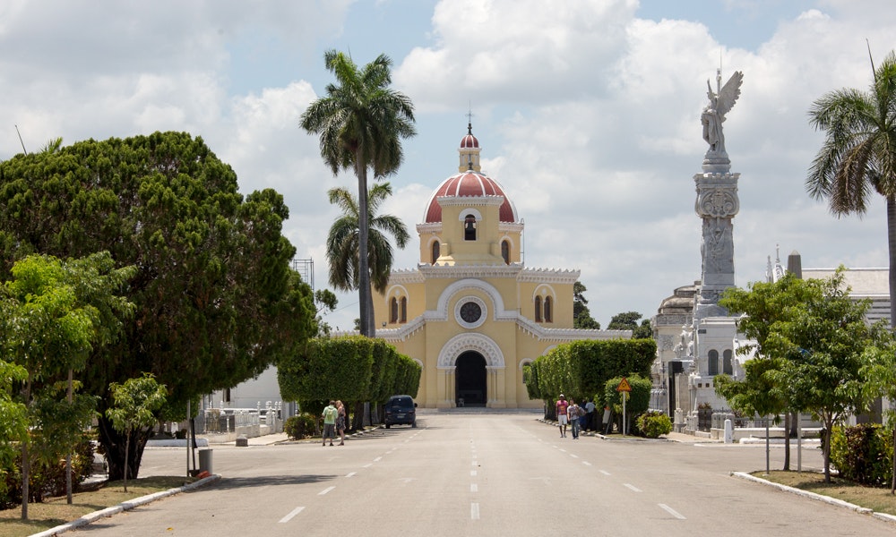 Cuba Unusual Museum Image: A photograph of the cemetery; pale yellow with a red roof. The streets are lined with trees.