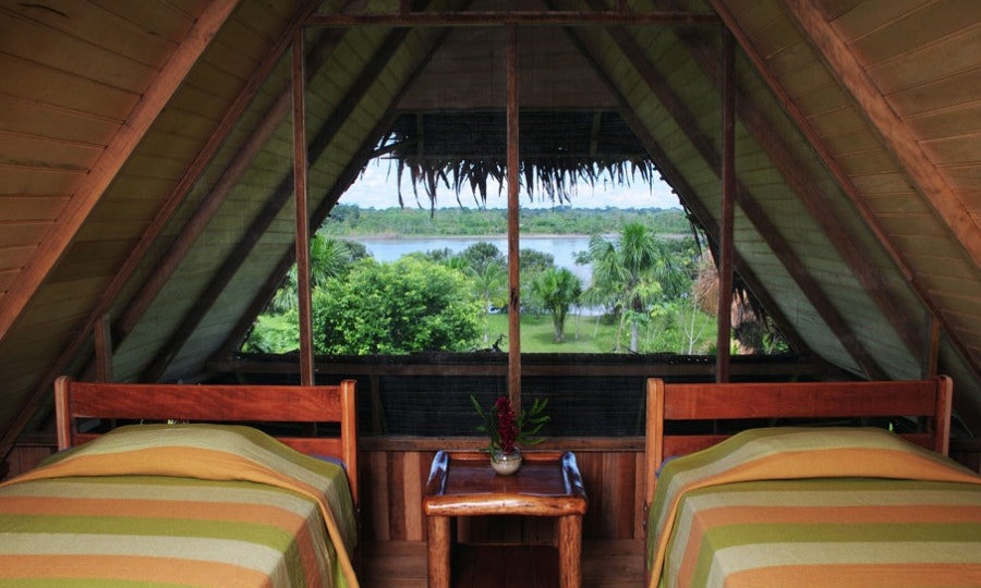 Peruvian Amazon Image: A suite with two beds at the Pacaya Samiria Lodge. We see an incredible view of the Amazon Rainforest.