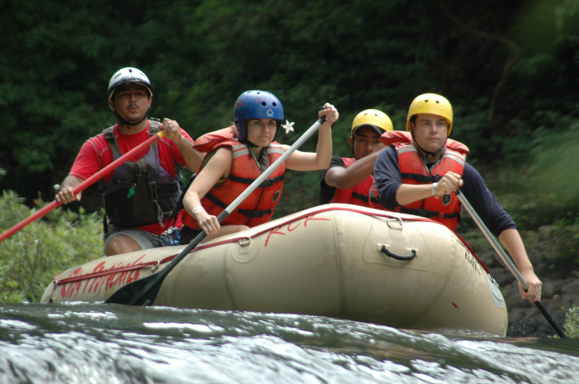 Costa Rica Rafting Image: Tenorio River. Four rafters with serious expressions concentrate on navigating the waters ahead of them.
