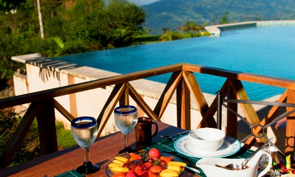 Accessible Travel Image: A breakfast of tropical fruit overlooks a beautiful swimming pool, and a rainforest.