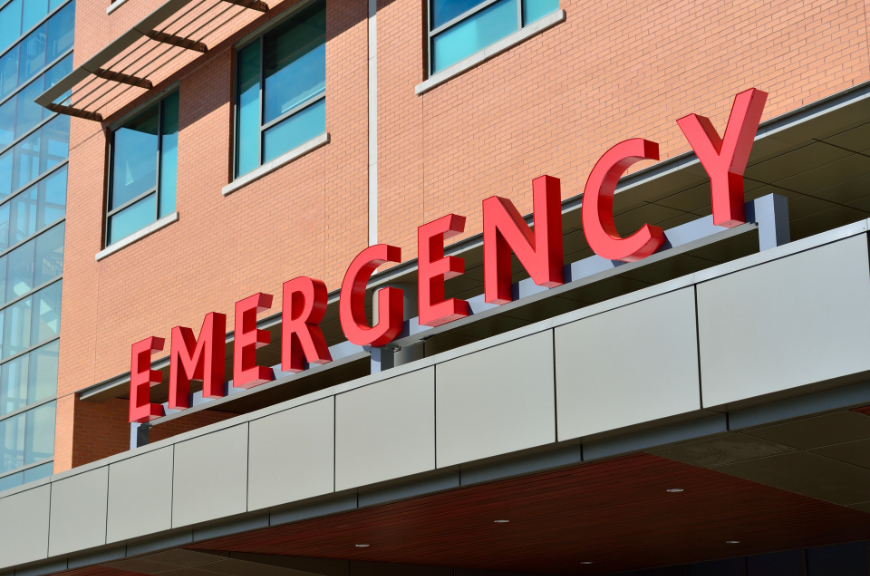 Altitude Sickness Image: A red 'emergency' sign on a red brick building.
