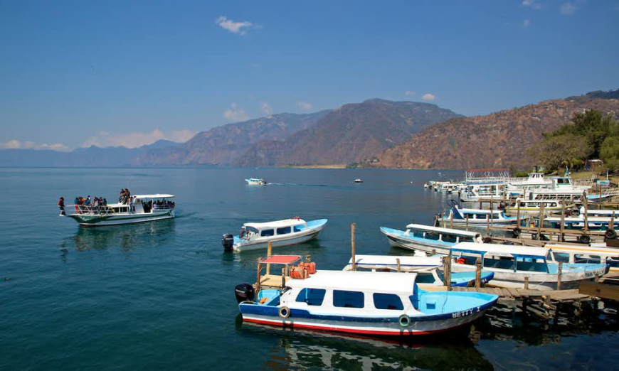 Belize and Guatemala Itinerary Image: A boat dock and mountains near the shores of Panajachel on Lake Atitlan.
