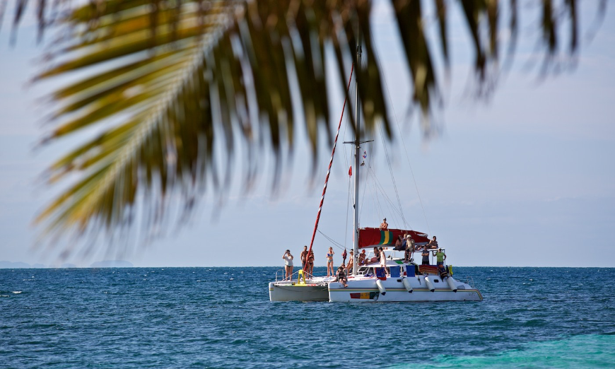 Belize Island Image: A group of people are enjoying a sunny day on a catamaran.