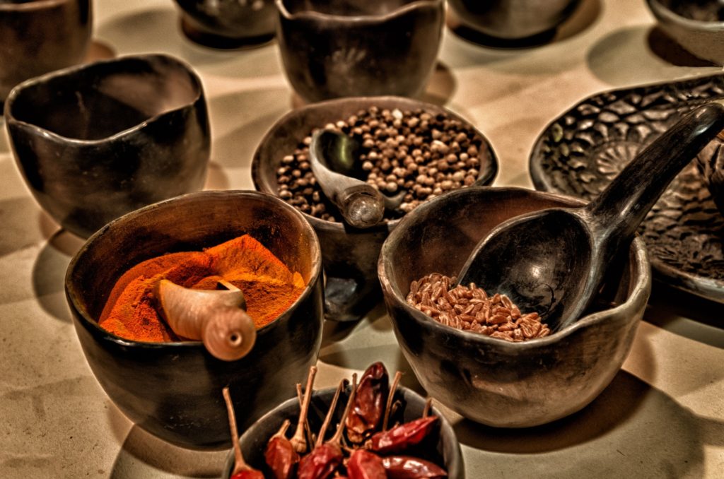 Best Chocolate Image: Old pottery bowls with scoops are filled with chili peppers, paprika, allspice, and what is possibly anise seed or cacao nibs. 