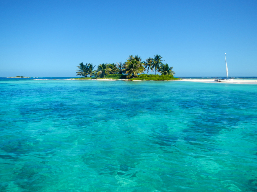 Best time to visit Central America Image: Beautiful turquoise colored water near an idyllic island barrier reef in Belize.