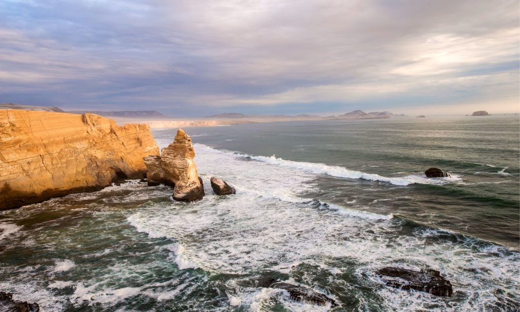Best Time To Visit South America Image: Peru's Cathedral Rock formation sits amidst ocean water.