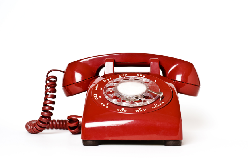 Booking A Vacation Online Image: A red rotary dial telephone.