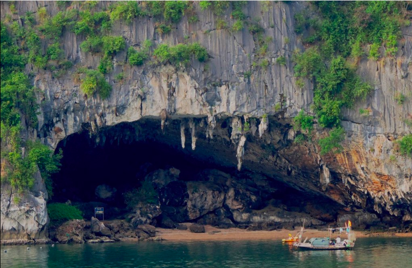 Caving in Vietnam Image: A boat and a kayak approach the entrance of Bo Nau Cave.