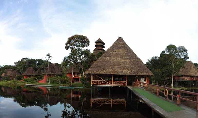 Destination Wedding in Ecuador Image: A pier and peaked thatched roof cabins. 