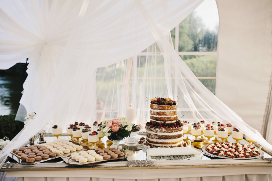 Destination Wedding in Ecuador Image: A dessert table has a wedding cake, cookies, parfaits, and more.