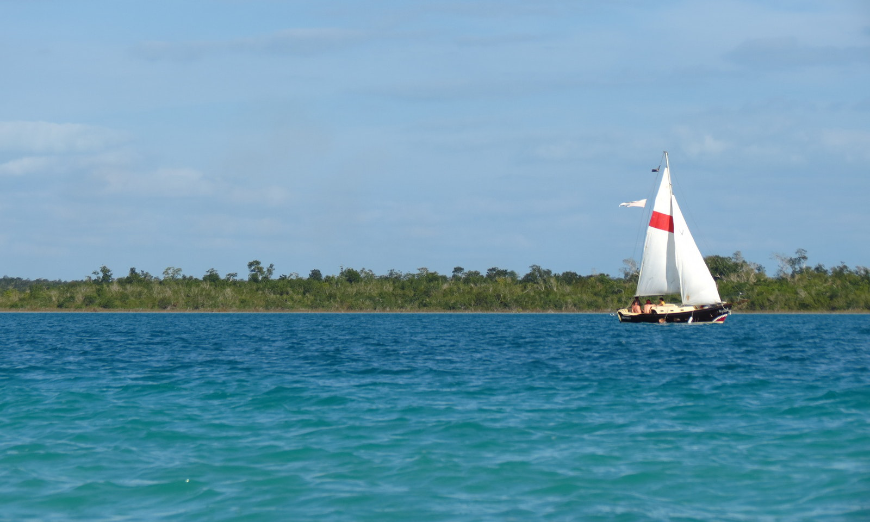 Diving In Belize Image: A sailboat is in the midst of Bacalar Chico Marine Reserve.