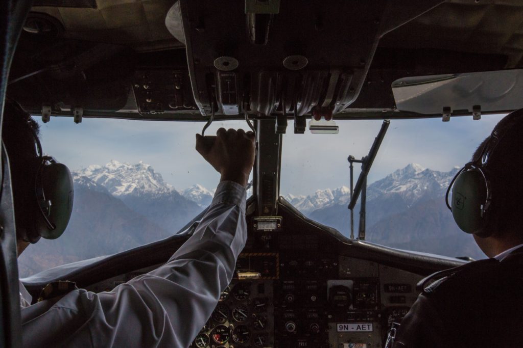 Everest Trek Image: The view from the cockpit of an airplane during the Everest Base Camp Trek. A pilot and co-pilot are off to the side navigating.