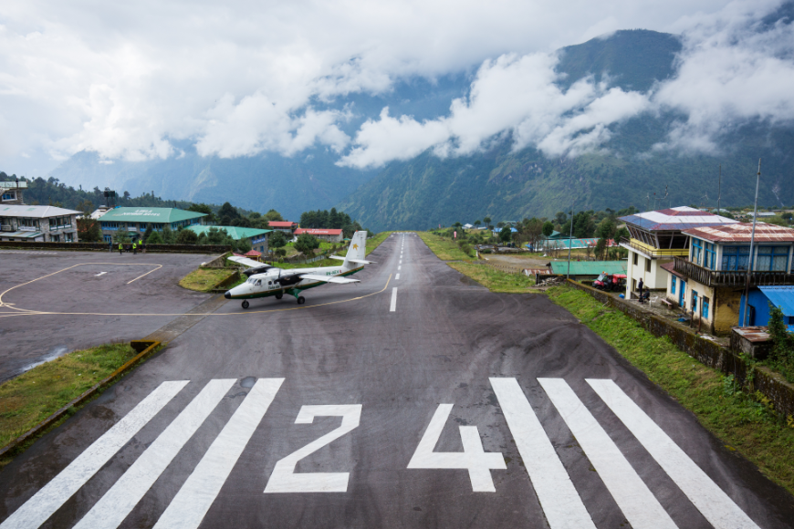 Everest Tattoo Image: A plane lands in Lukla Airport, surrounded by clouds and mountains. 