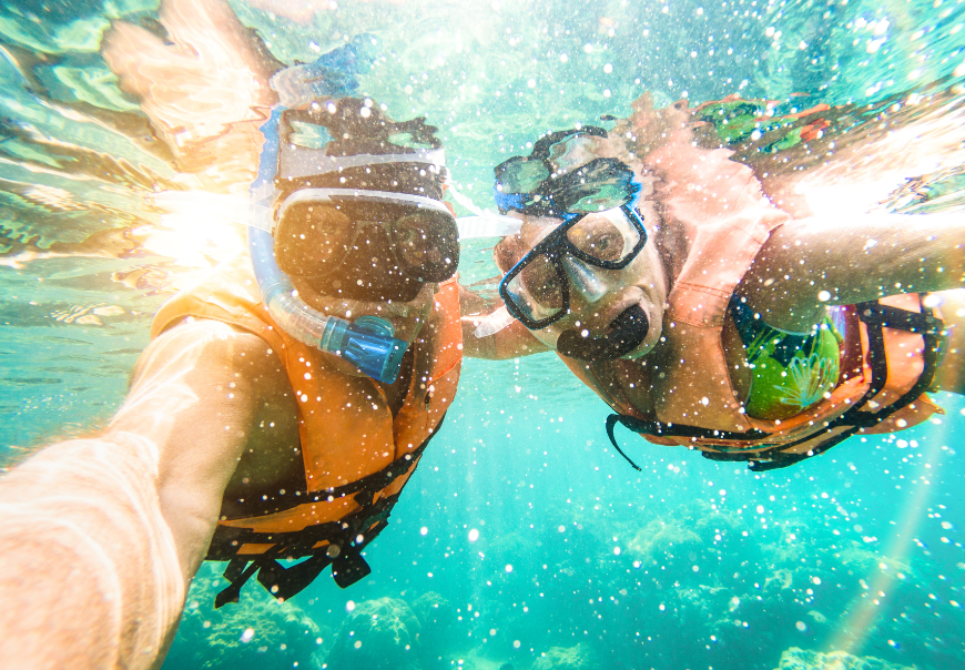 family vacations in belize and guatemala image: Two snorkelers take an underwater selfie.