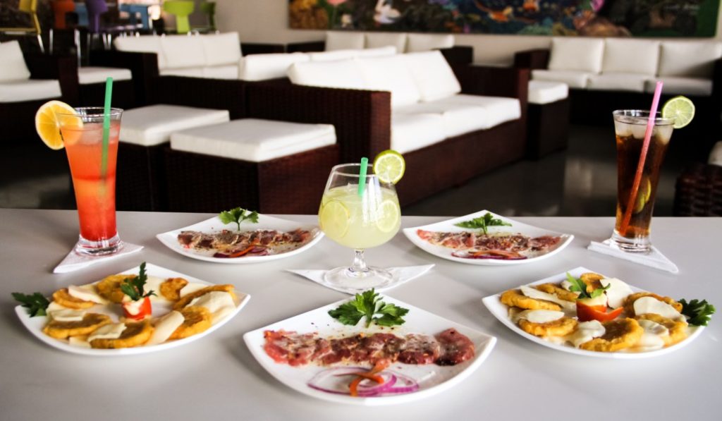 Galápagos Islands Image: A shot of the EcoGal VIP reception area shows well designed seating, and a variety of snacks and beverages on a white tablecloth.