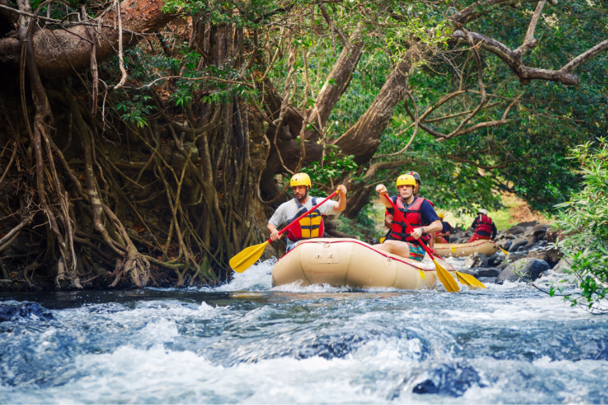 Green Season Image: Travelers enjoy a whitewater rafting adventure on a jungle's river.