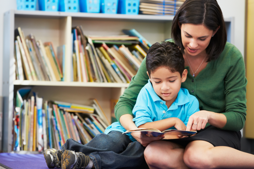 Imagination Bus Image: A mother or teacher sits and reads with a young boy.