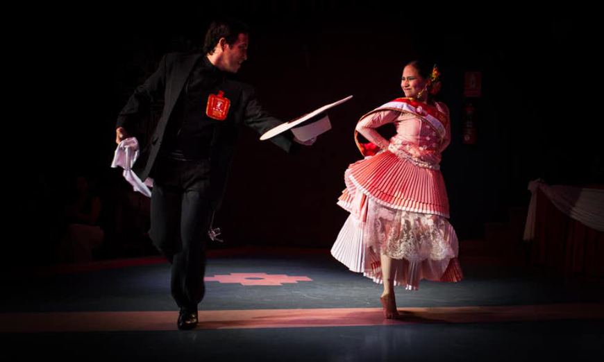 Lima Nightlife Image: Two dancers on stage in traditional dress — man in suit and hat, woman in tiered dress.