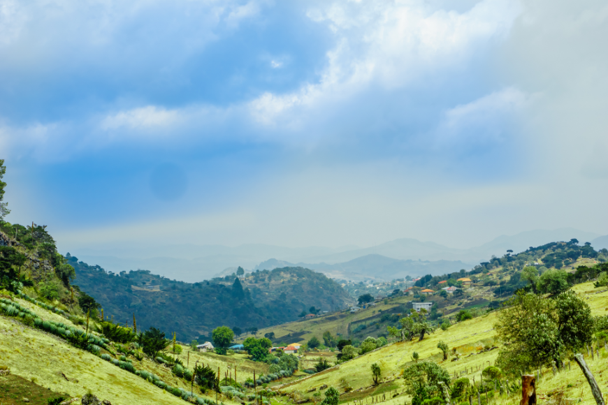 Mayans of Guatemala Image: A landscape of rolling green hills, mountains, and clouds.