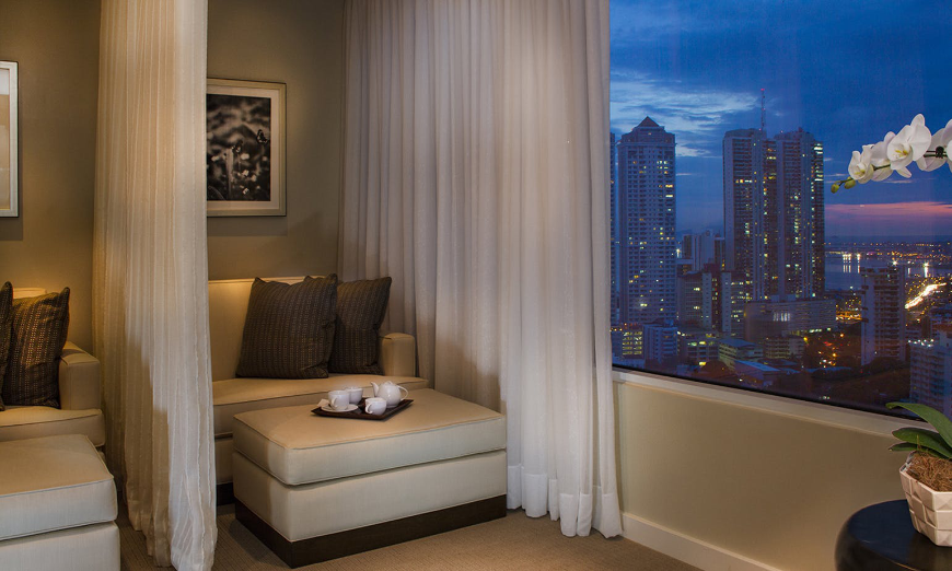 Moving to Panama Image: A seat in a luxurious room decorated in neutral tones looks out onto an exquisite view of the city.