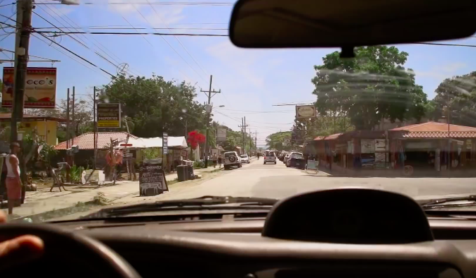 Is It Safe to Travel in Costa Rica Image: View of a town through a driver's windshield.