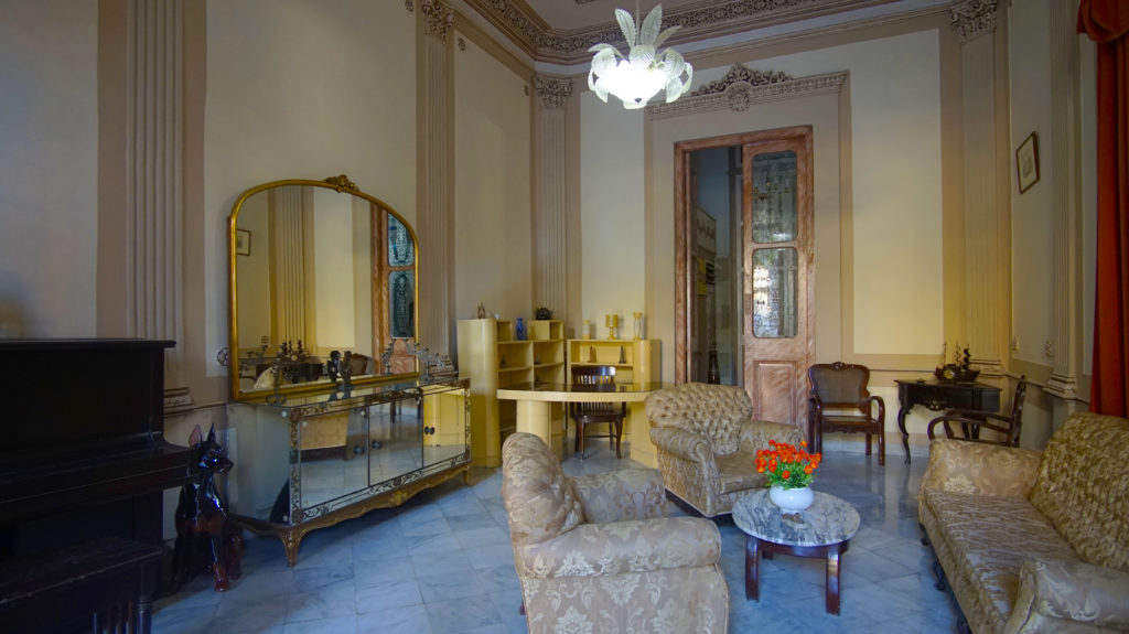 Legally Travel To Cuba Image: An interior view of Casa Prado Colonial shows a nicely decorated sitting room, intended to pull together the home's colonial aesthetic.