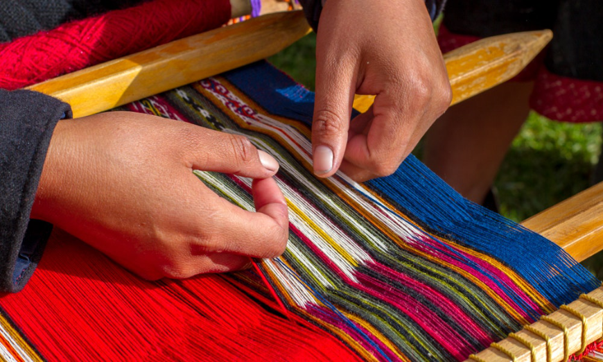 Peruvian Souvenirs Image: Hands skillfully craft a textile on a loom.