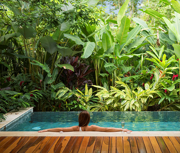 Unique Honeymoon Image: A woman sits in a private pool with her arms relaxing on the pool's edge.