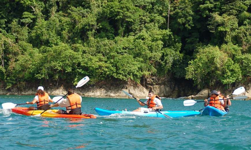 Why Choose A Travel Agent Image: Five people enjoy kayaking.