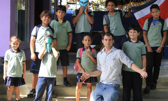Why Is Costa Rica The Happiest Country Image: Schoolchildren and their teacher pose in front of steps.